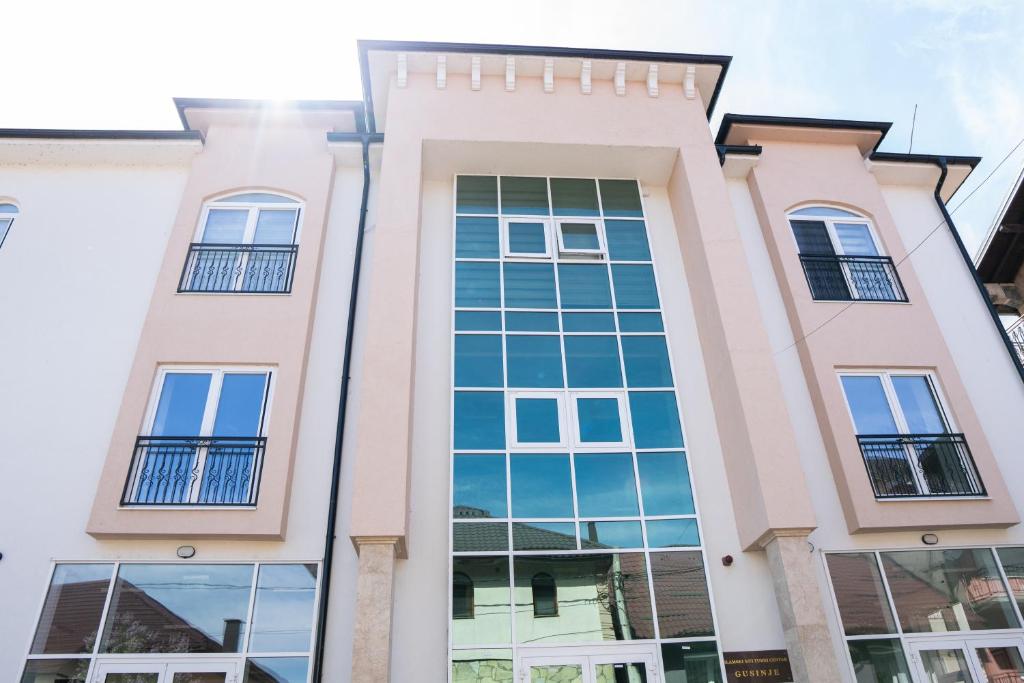a facade of a building with windows at Hotel Han Gusinje in Gusinje