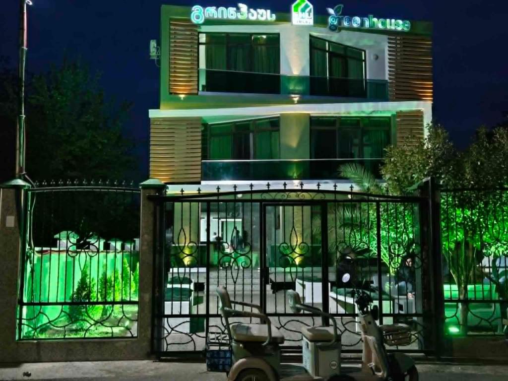 a building with a gate and chairs in front of it at Green House in Ureki