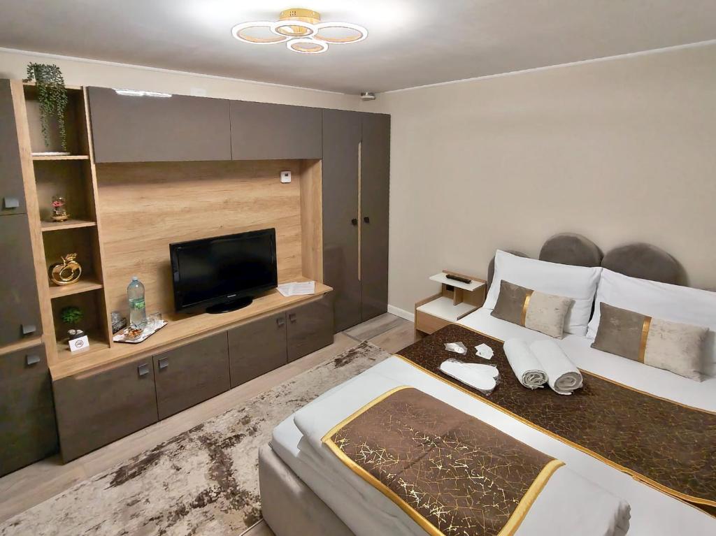 a bedroom with a large bed and a flat screen tv at Delfinului Retreat in Ovidiu