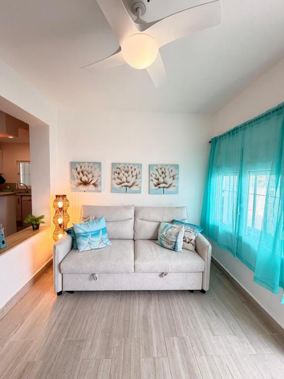 a living room with a couch and a ceiling fan at Brisas del mar in Faro de Cullera