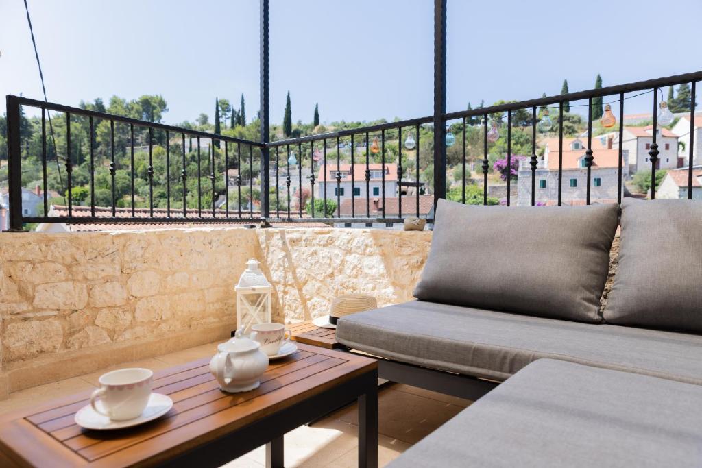 a balcony with a couch and a table with a view at Stone house Sprtini-Brač in Ložišće