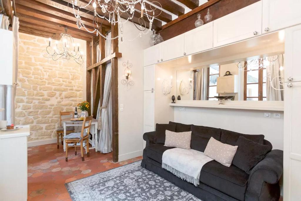 un salon avec un canapé noir et une table dans l'établissement Le Diamant En Isle, à Paris