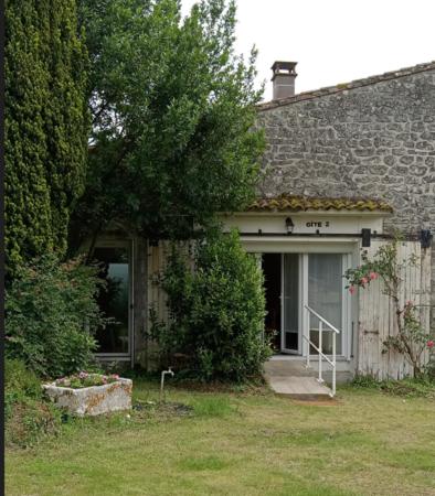 a stone house with a tree in the yard at Gite 2 des Ecuries du Seillery in La Clisse