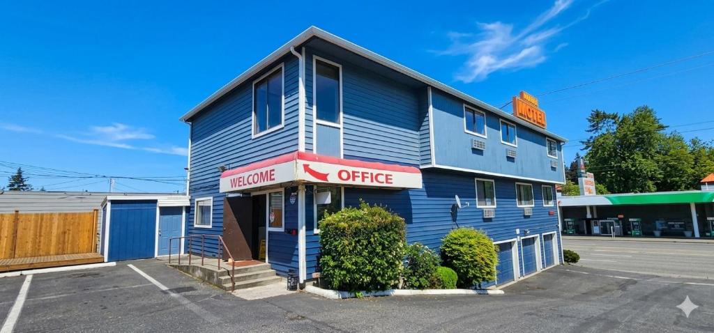 a blue building with a sign that reads former office at Farwest Motel in Everett