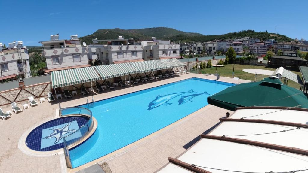 a swimming pool with a dolphin in the middle at Alptekin Otel in Ürkmez
