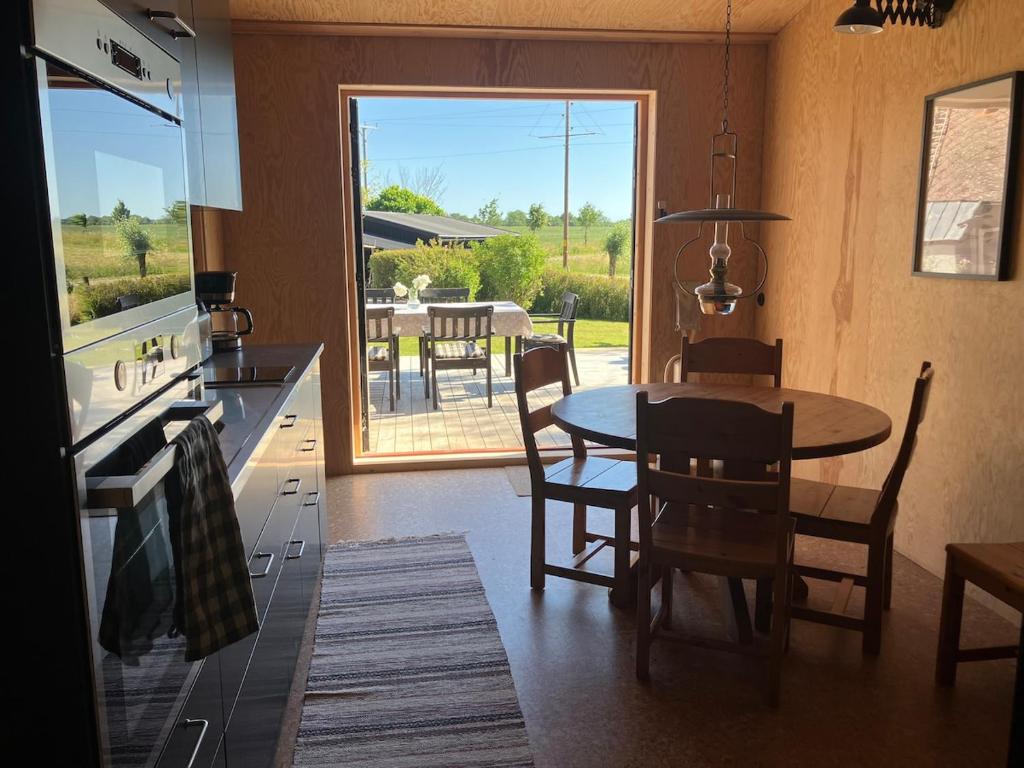 a kitchen and dining room with a table and chairs at The forest in Sjöbo