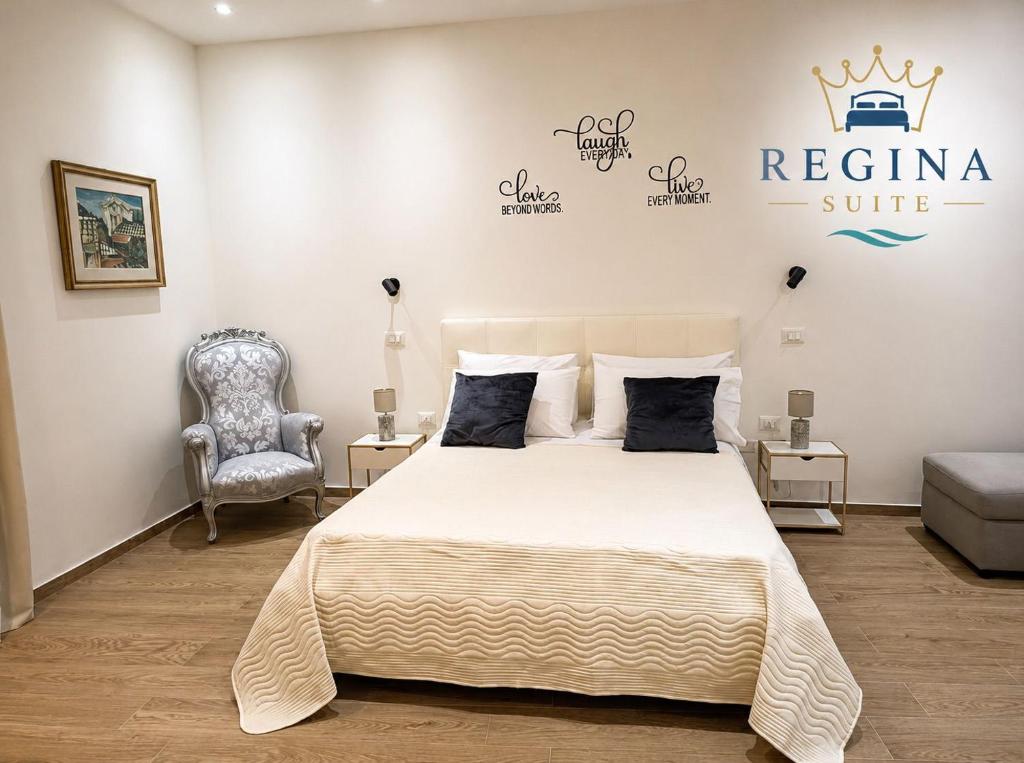 a bedroom with a king sized bed and a chair at Regina Suite Mazara in Mazara del Vallo
