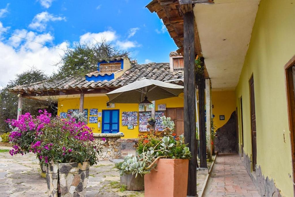 a yellow house with flowers in front of it at Cabaña privada en Oicata in Oicatá