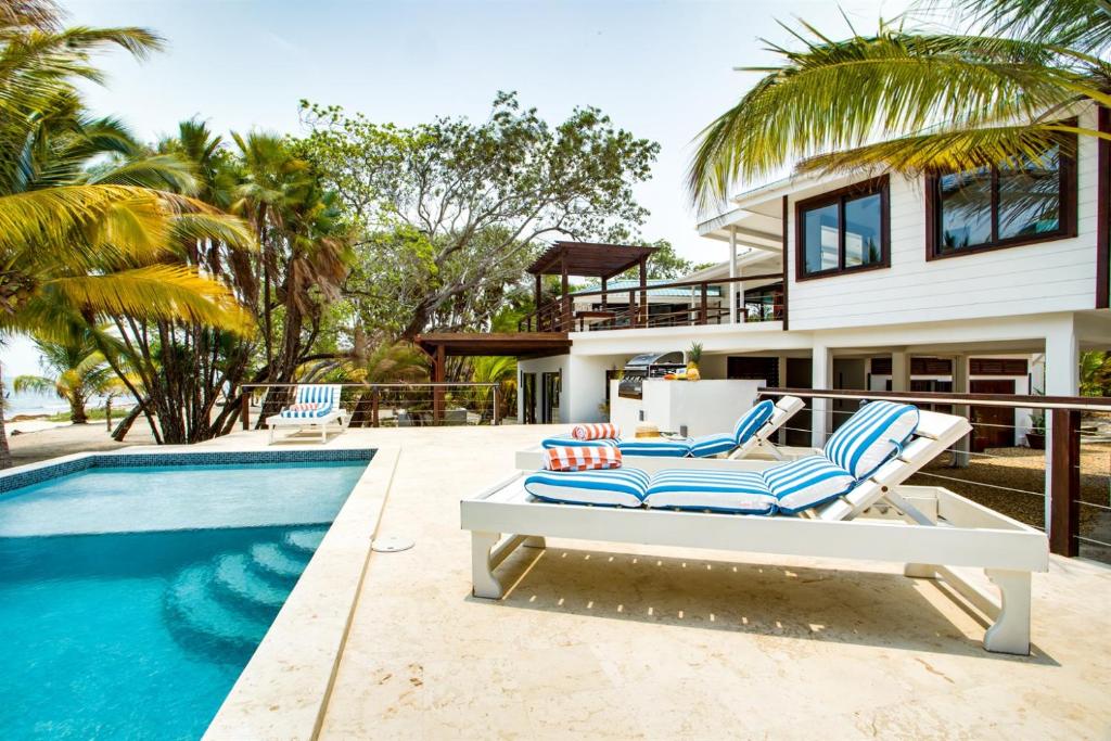 a villa with a swimming pool and a house at Picture-Perfect 2-Bedroom Oceanfront Home w Pool in Placencia
