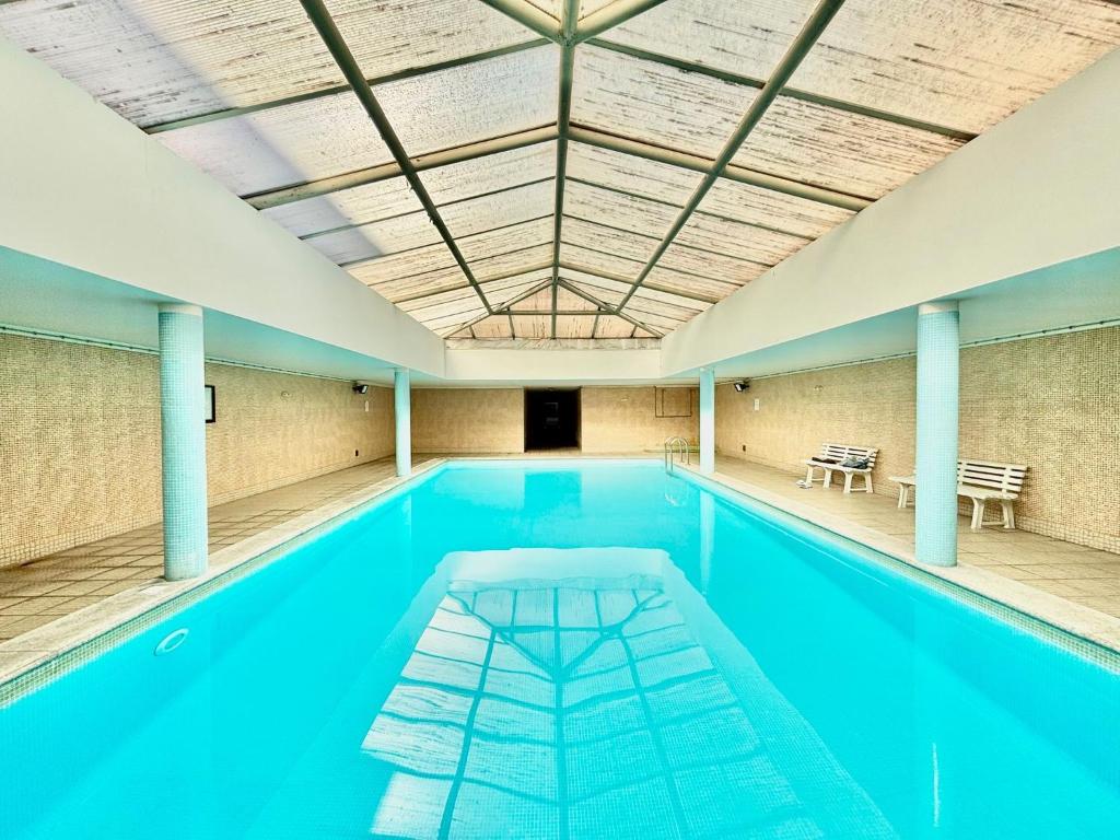 a swimming pool with blue water in a building at NCHouse in Esposende