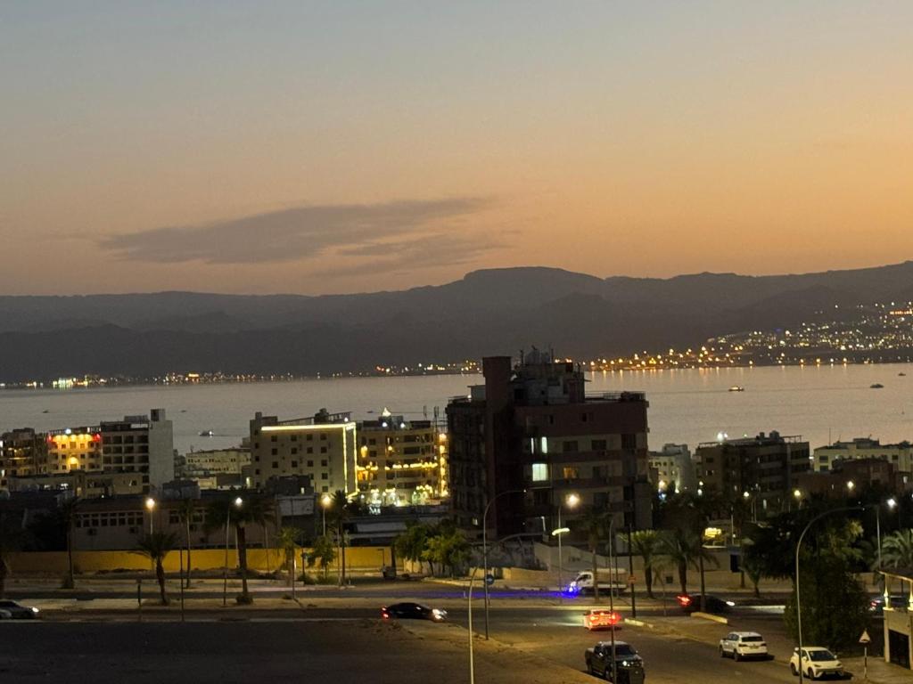 a view of a city at night with the water at شقق الخامسه الفاخرة Al Amer Luxury Apartments in Aqaba