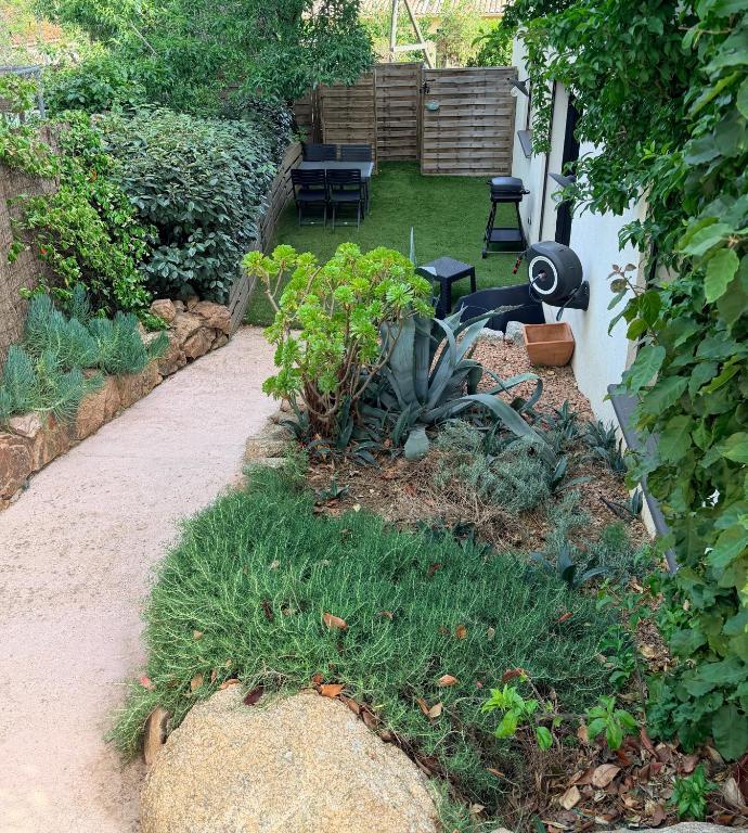 a garden with a patio with a table and chairs at Chez Fred et Marie in Figari