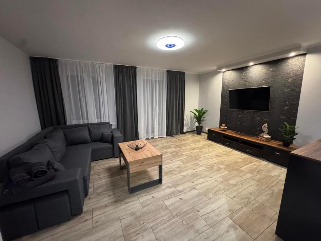 a living room with a couch and a flat screen tv at Apartament W Cieniu Twierdzy in Kłodzko