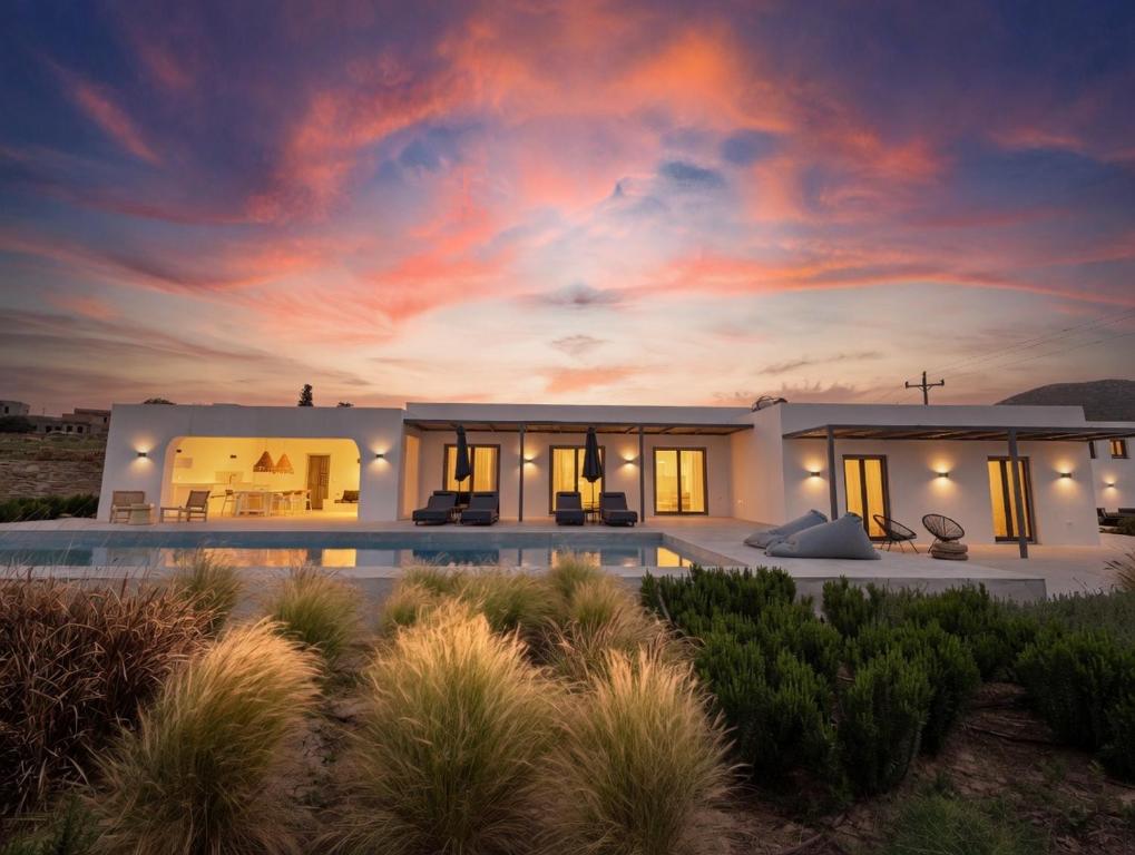 a villa with a swimming pool at sunset at Faragas Hill Harmony Villa in Angairiá