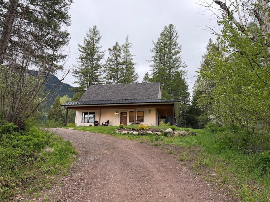 a small house on a dirt road next to a road at Hungry Horse Farmhouse in Hungry Horse