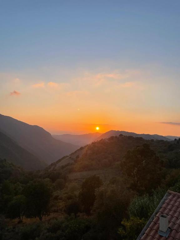 a sunset over a mountain range with the sun setting at Noce Melano in Montattico
