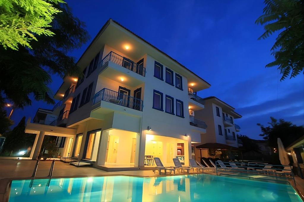 a villa with a swimming pool at night at Marigold Otel in Çeşme