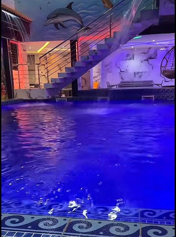 a swimming pool with a dolphin painted on the wall at RÉSIDENCE MAME DIARRA kl in Kaolack
