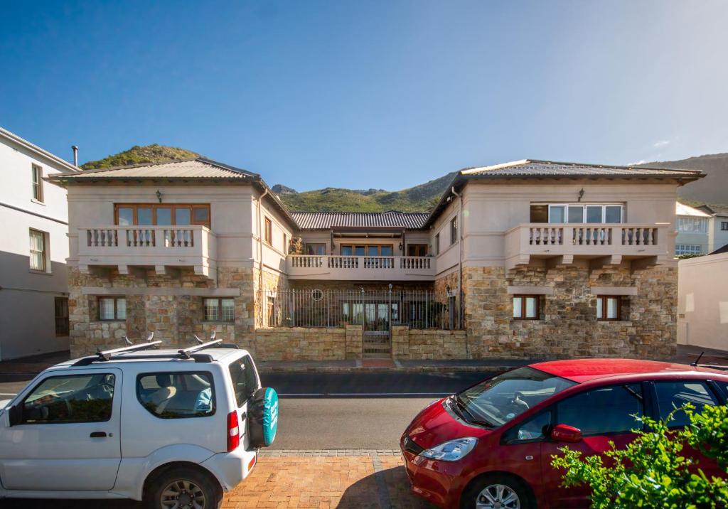 two cars parked in front of a large building at Millwood Apartment in Cape Town