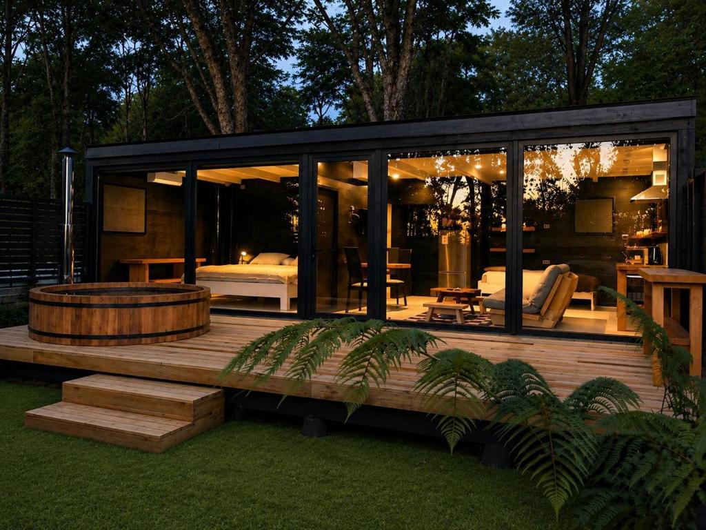 a large glass house with a bench and a table at Calma Lodge in Puerto Clocker
