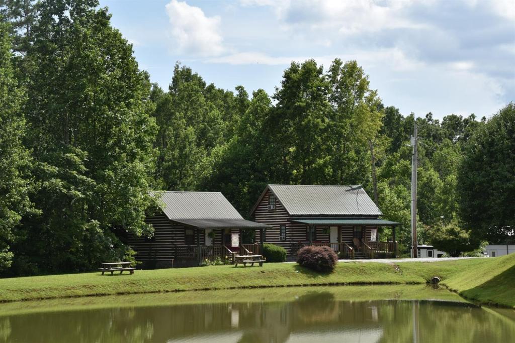 a log cabin with a pond in front of it at Laurel Lake Cabins in Corbin