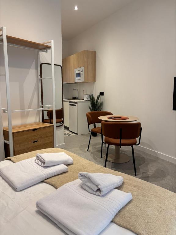 a room with a kitchen and a table with towels at La Encina Suites in Salamanca
