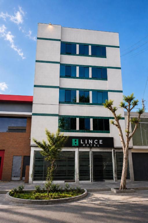 a large white building with a garage at Hotel Lince in Lima