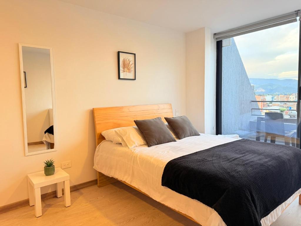 a bedroom with a bed and a large window at Exclusivo Apartamento Céntrico con Terraza Privada in Sogamoso
