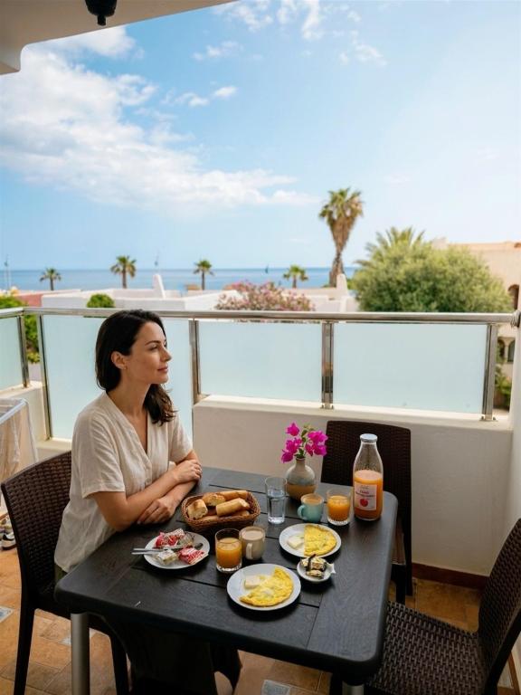 a woman sitting at a table with breakfast food at Visit Chamal - Horizon View in Oued Laou