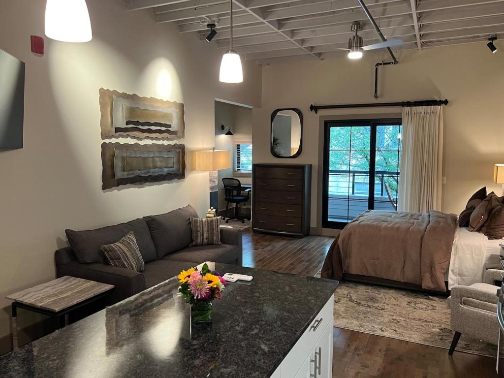 a living room with a couch and a bed at Downtown Suite with Balcony in Syracuse