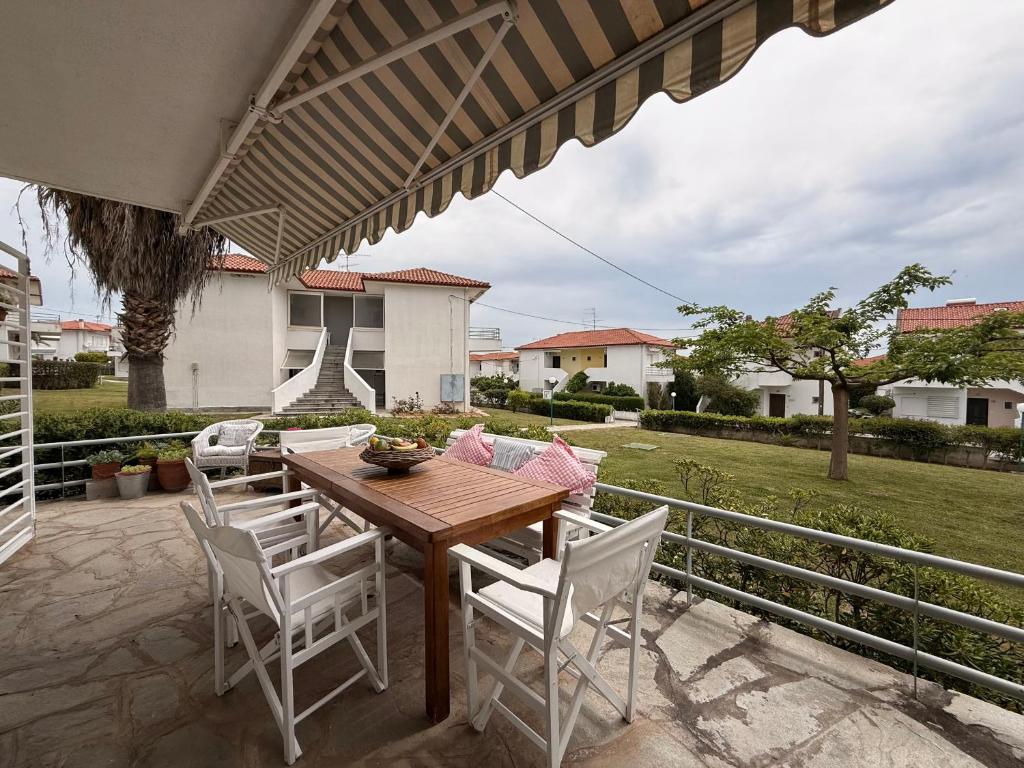 a wooden table and chairs on a patio at Ellis house Agnanti in Kalives Poligirou