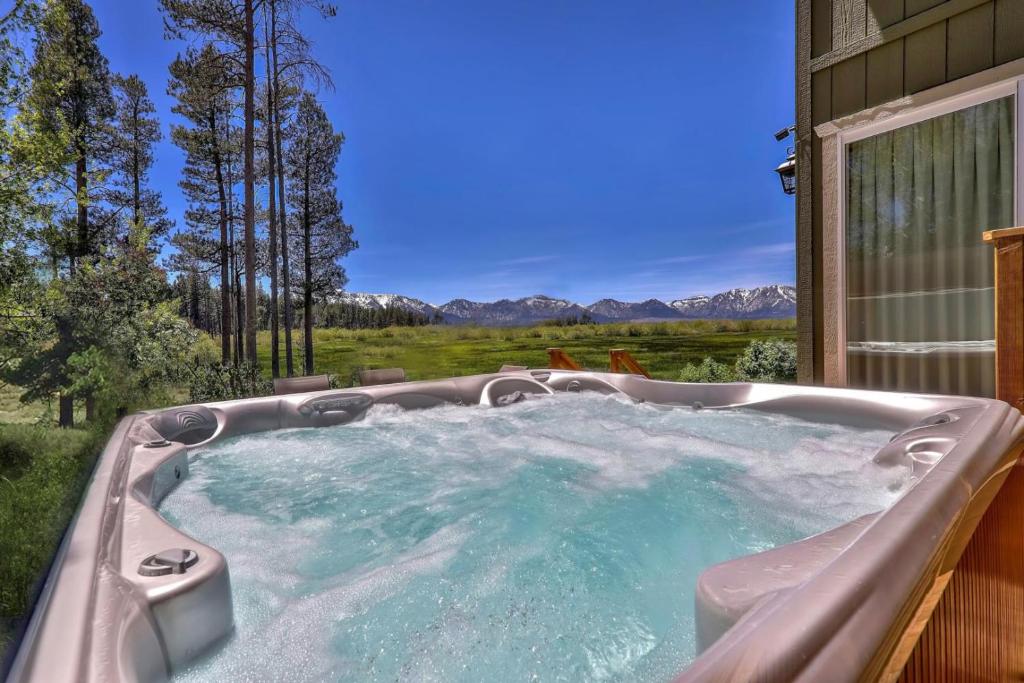 a jacuzzi tub with a view of the mountains at Tahoe Retreat on the Meadow- Hot Tub AC in South Lake Tahoe