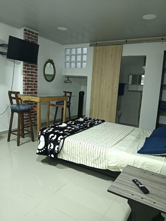 a bedroom with a bed and a desk and a table at APARTAMENTOS Don GUILLE in Santa Rosa de Cabal