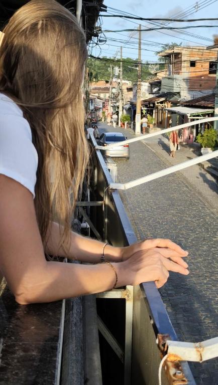 a woman leaning on a railing looking out over a city at Casa 89 in Itacaré
