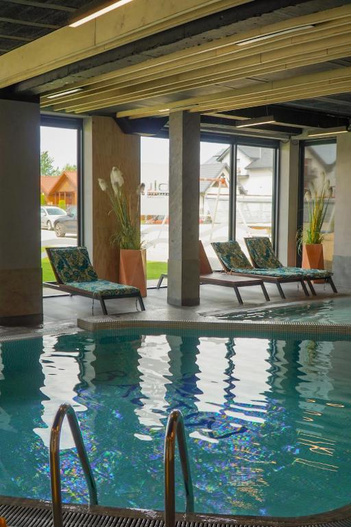 a pool at a hotel with chaise lounge chairs at Przystań Apartamenty Sarbinowo in Sarbinowo