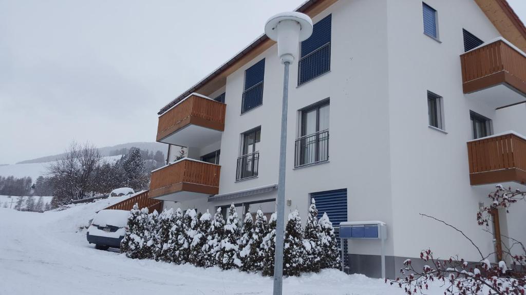 ein schneebedecktes Gebäude mit einem daneben geparkt in der Unterkunft Chasa Scandella - Apartment Carl in Sent