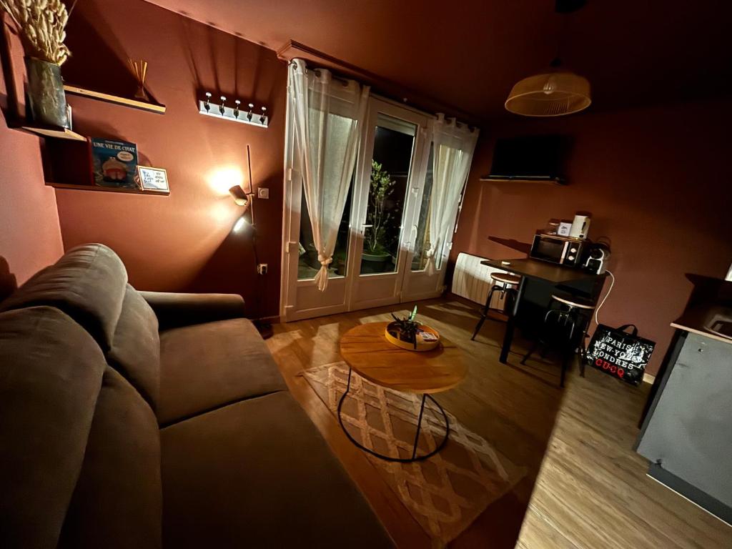 a living room with a couch and a table at Le Studio de Paulette in Cucq