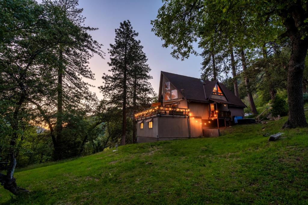 a house on a hill with lights on it at Hygge Haus Sequoia - Large Private Cabin w Views in Ponderosa
