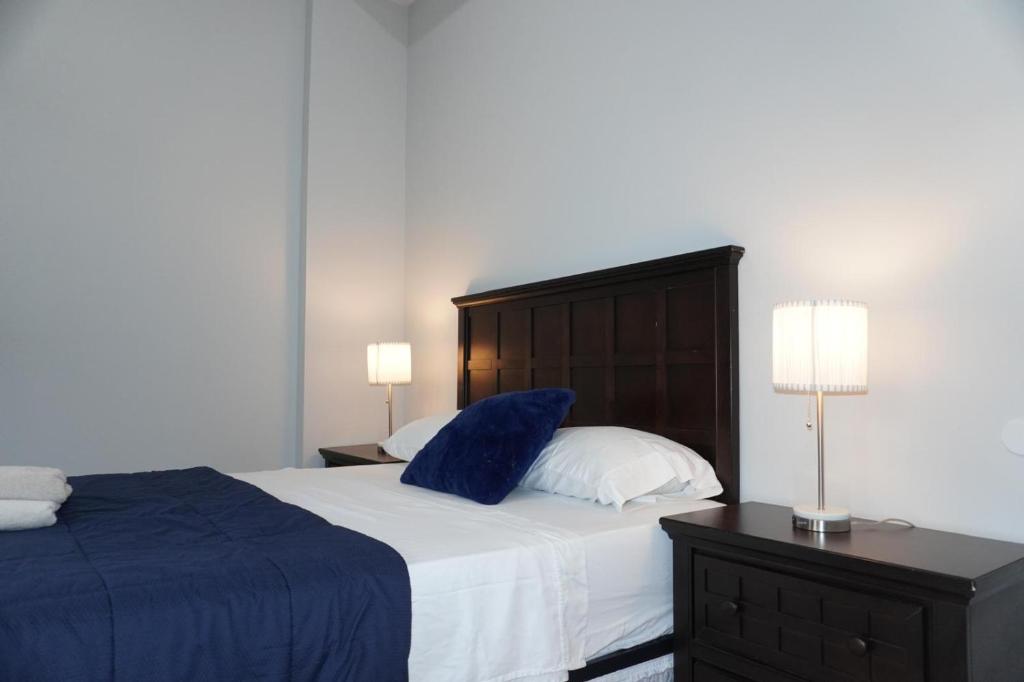 a bedroom with a large bed with blue sheets and pillows at New York view 37 in West New York