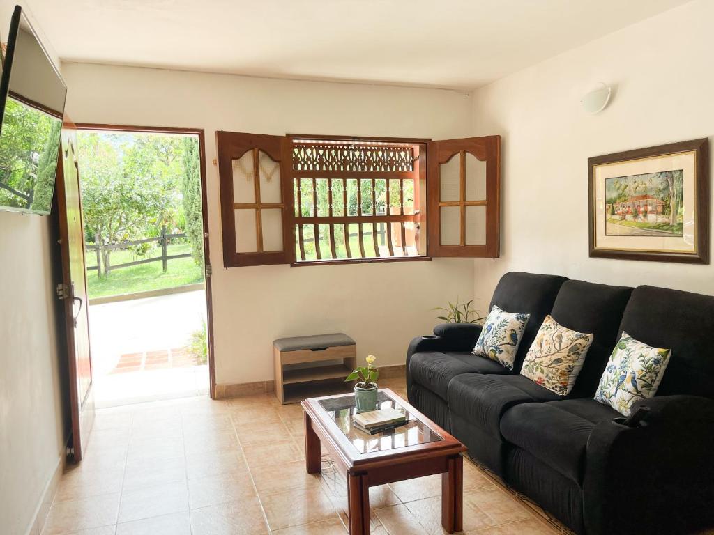 a living room with a black couch and a table at Casa El Pinar in Jardin