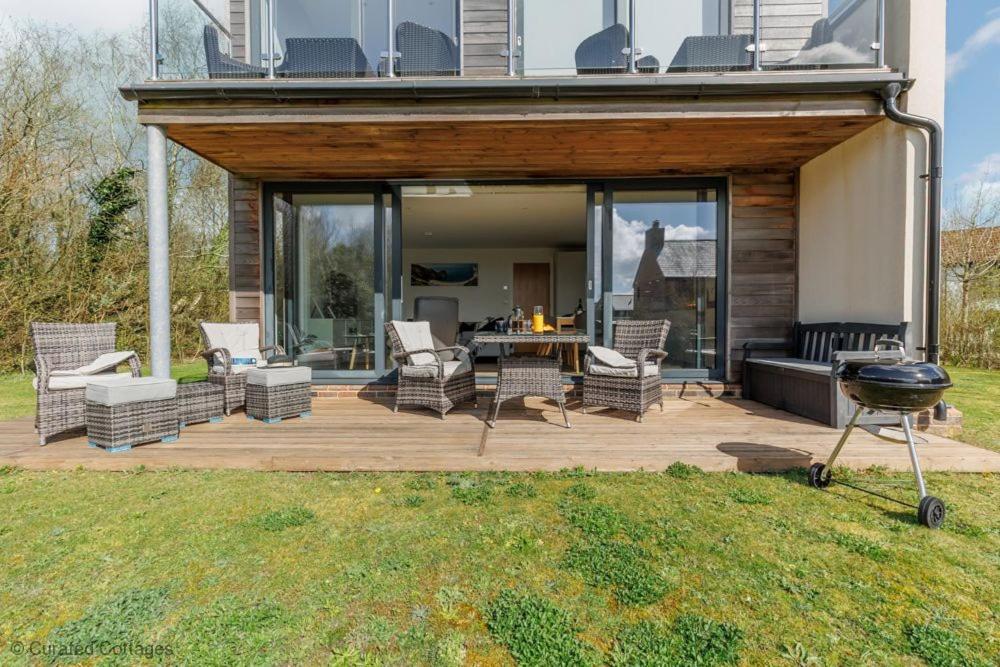 a patio with chairs and a grill in a yard at Little Spinney in Dorchester