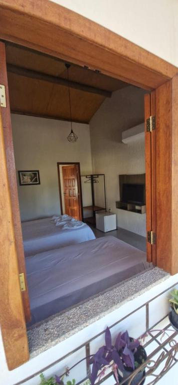 a bed with a wooden frame in a bedroom at Chalés e Suítes Campos de São João in Palmeiras