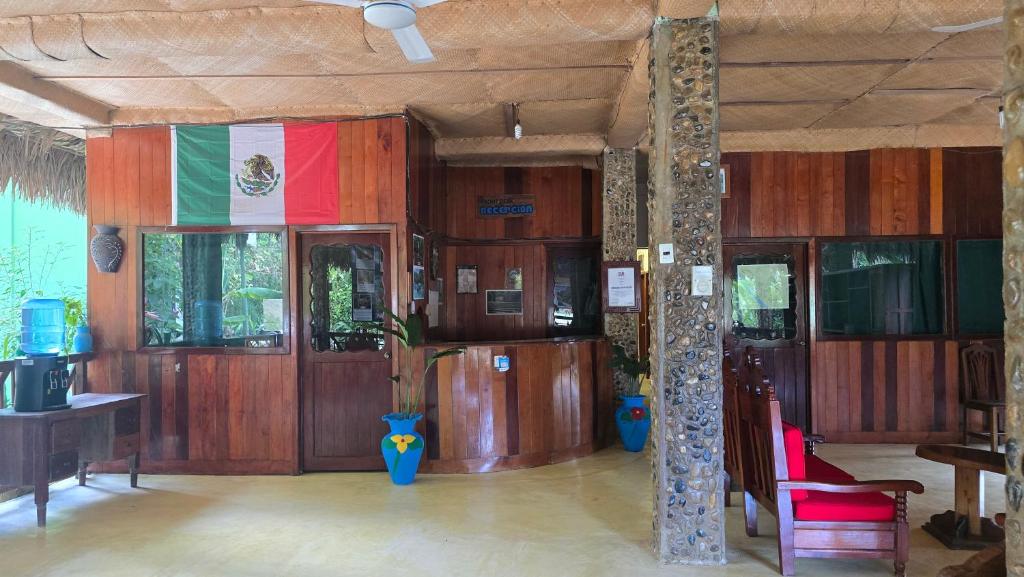 ein Zimmer mit Holztüren und einer Flagge an der Wand in der Unterkunft Hotel Nueva Alianza in Frontera Corozal