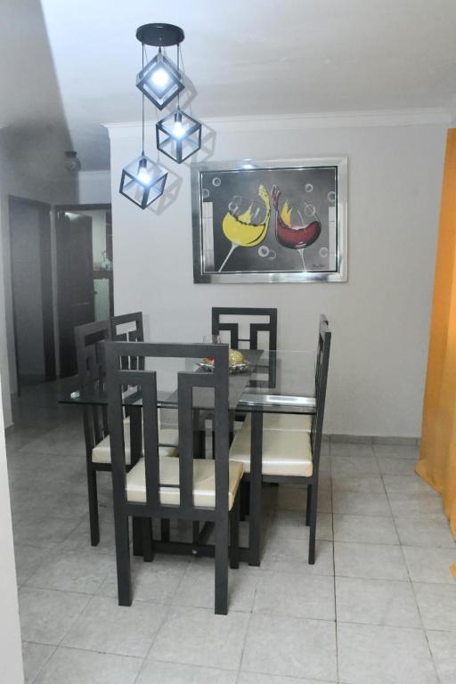 a dining room with a table and chairs and a picture of bananas at Vacacional rent in Boca Chica