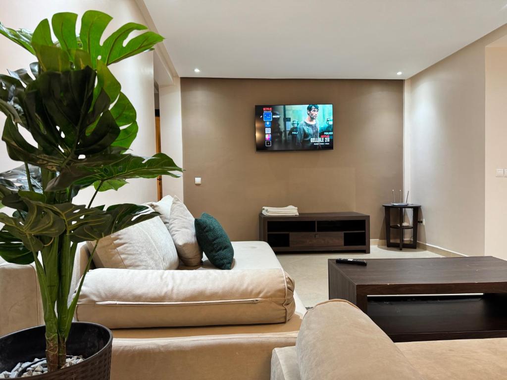 a living room with a couch and a tv at Calma in Beni Mellal