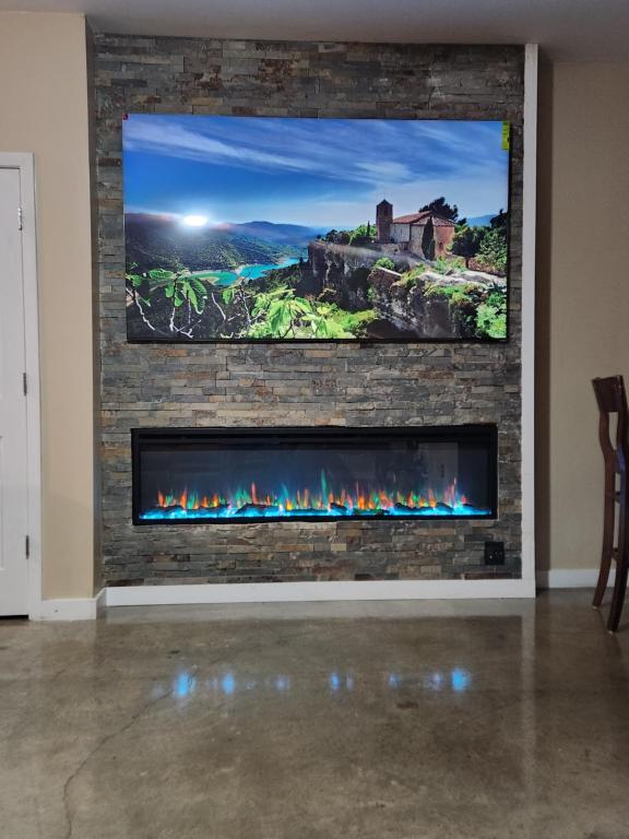 a tv mounted on a brick wall with a fireplace at Just like home in Atlanta