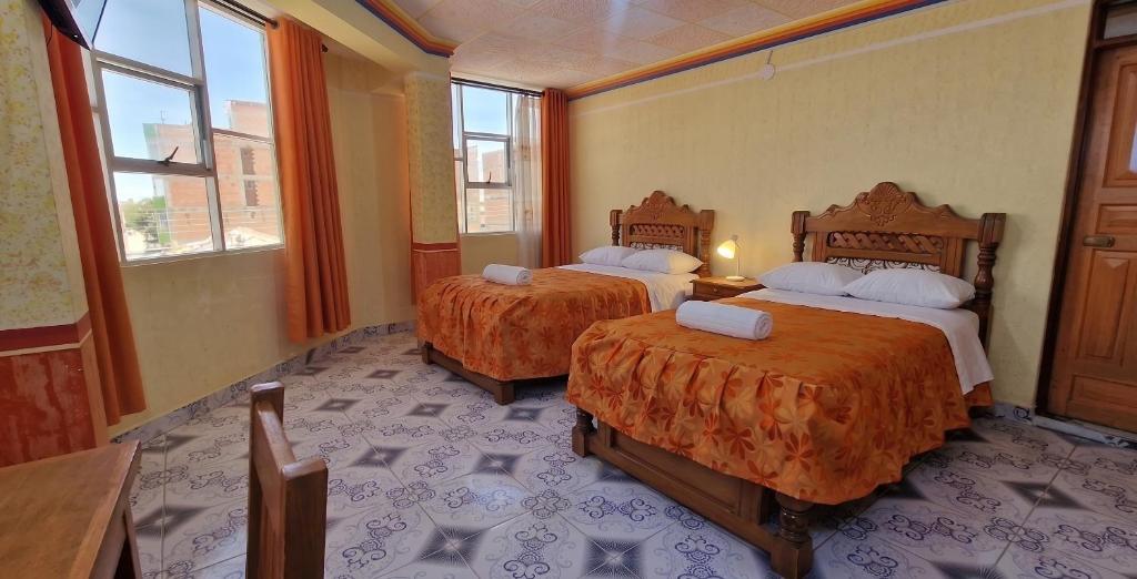 a hotel room with two beds and two windows at Sunset - Puesta de Sol in Uyuni