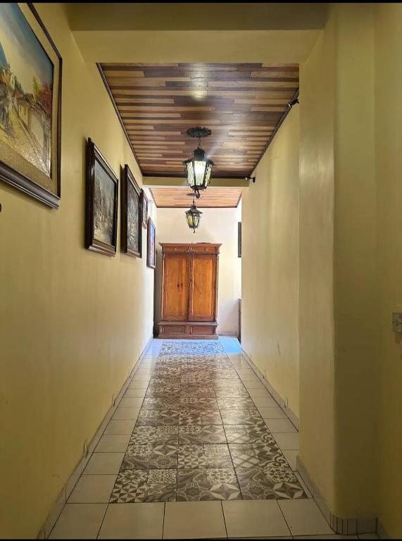 a hallway with a wooden door and a tile floor at Suites Central in Guadalajara