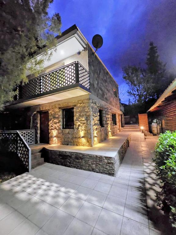 a stone house with a porch with lights on it at Cabaña Pica Piedra in Mendoza