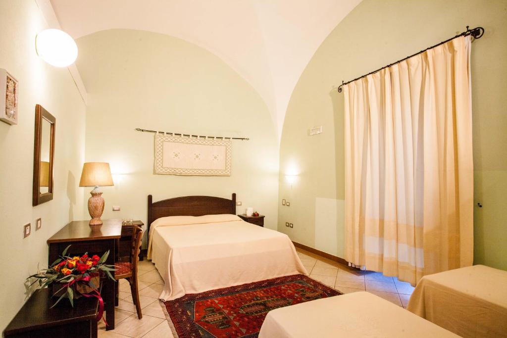 a hotel room with a bed and a dresser at Hotel Il Duomo in Oristano